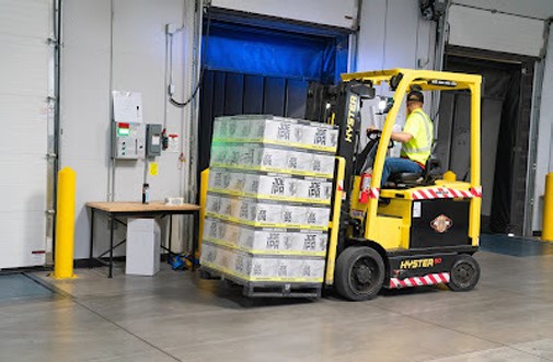 Forklift moving palletized goods at the loading bay